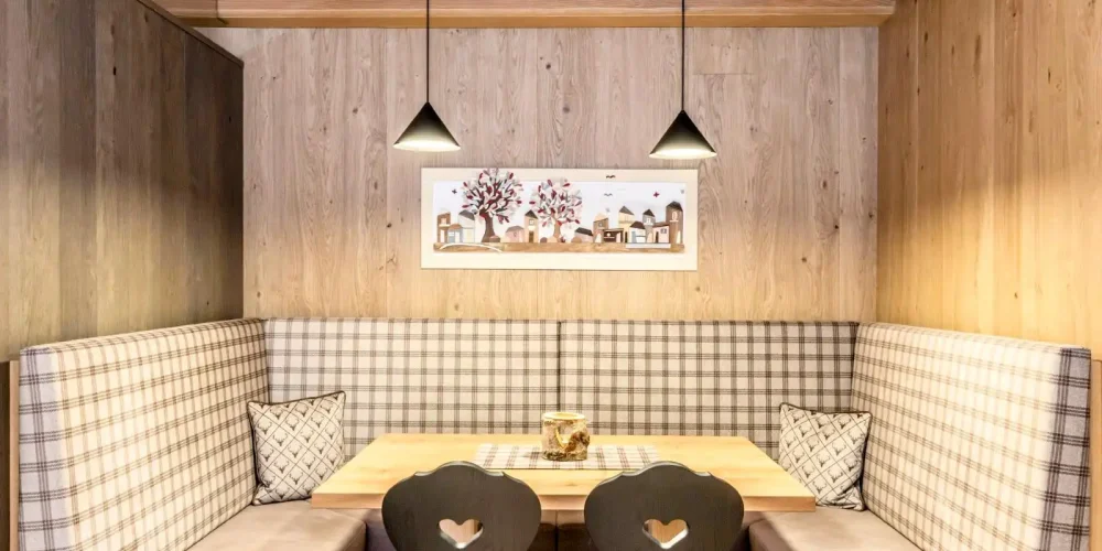 Un'accogliente zona pranzo con arredi in legno e sedute imbottite a scacchi.